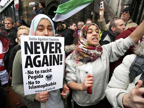 Girl holds a placard as she takes part in a counter-demonstrations against Pegida movement in Newcastle, northern England, 2015-03-27